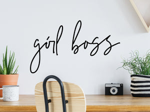 Decorative wall decal that says ‘Girl Boss’ on an office wall.