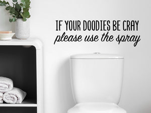 Wall decals for bathroom that say ‘If Your Doodies Be Cray Please Use The Spray’ in a cursive font on a bathroom wall.