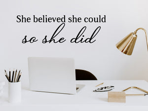 Wall decal for the office that says ‘She Believed She Could So She Did’ in a script font on an office wall.