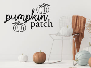 Living room wall decals that say ‘Pumpkin Patch’ in a script font on a living room wall. 
