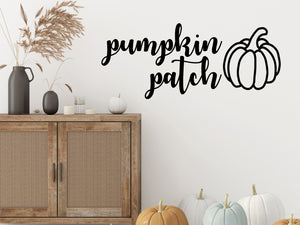 Living room wall decals that say ‘Pumpkin Patch’ in a cursive font on a living room wall. 
