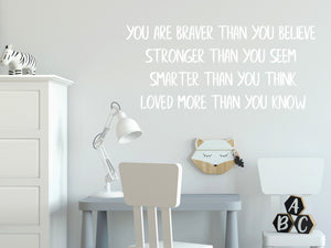 Wall decal for kids in a white color that says ‘You Are Braver Than You Believe’ in a print font on a kid’s room wall. 