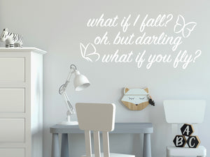 Wall decal for kids in a white color that says ‘What If I Fall, Oh But My Darling, What If You Fly?’ in a cursive font on a kid’s room wall. 