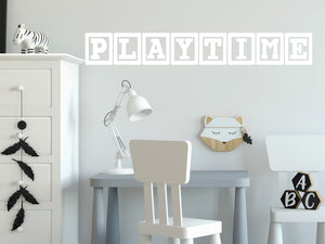 Wall decal for kids that says ‘Playtime’ in white with blocks on a kid’s room wall. 