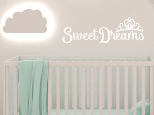 Wall decal for kids in a white color that says ‘Sweet Dreams’ in a cursive font on a kid’s room wall. 