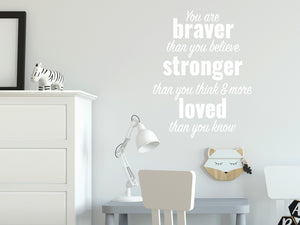 Wall decal for kids in a White color that says ‘You Are Braver Than You Believe’ in a dual font on a kid’s room wall. 