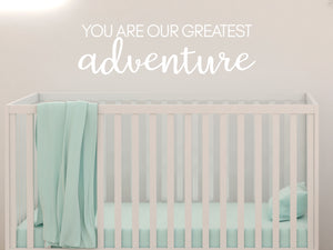 Wall decal for kids in a white color that says ‘You Are Our Greatest Adventure’ in a script font on a kid’s room wall. 