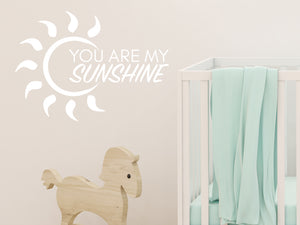 Wall decal for kids in a white color that says ‘You Are My Sunshine’ with a sun design on a kid’s room wall. 