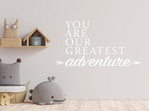 Wall decal for kids in a white color that says ‘You Are Our Greatest Adventure’ with an arrow design on a kid’s room wall. 