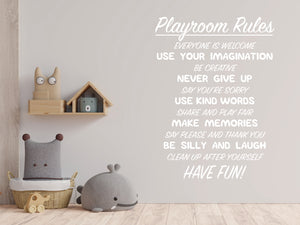 Living room wall decals that say ‘Playroom Rules’ in white on a living room wall. 