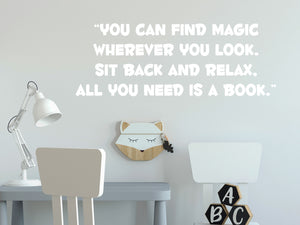 Wall decal for kids in a white color that says ‘You Can Find Magic Wherever You Look’ in a bold font on a kid’s room wall. 