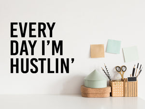 Wall decal for the office that says ‘Every Day I'm Hustlin'’ in a print font on an office wall.